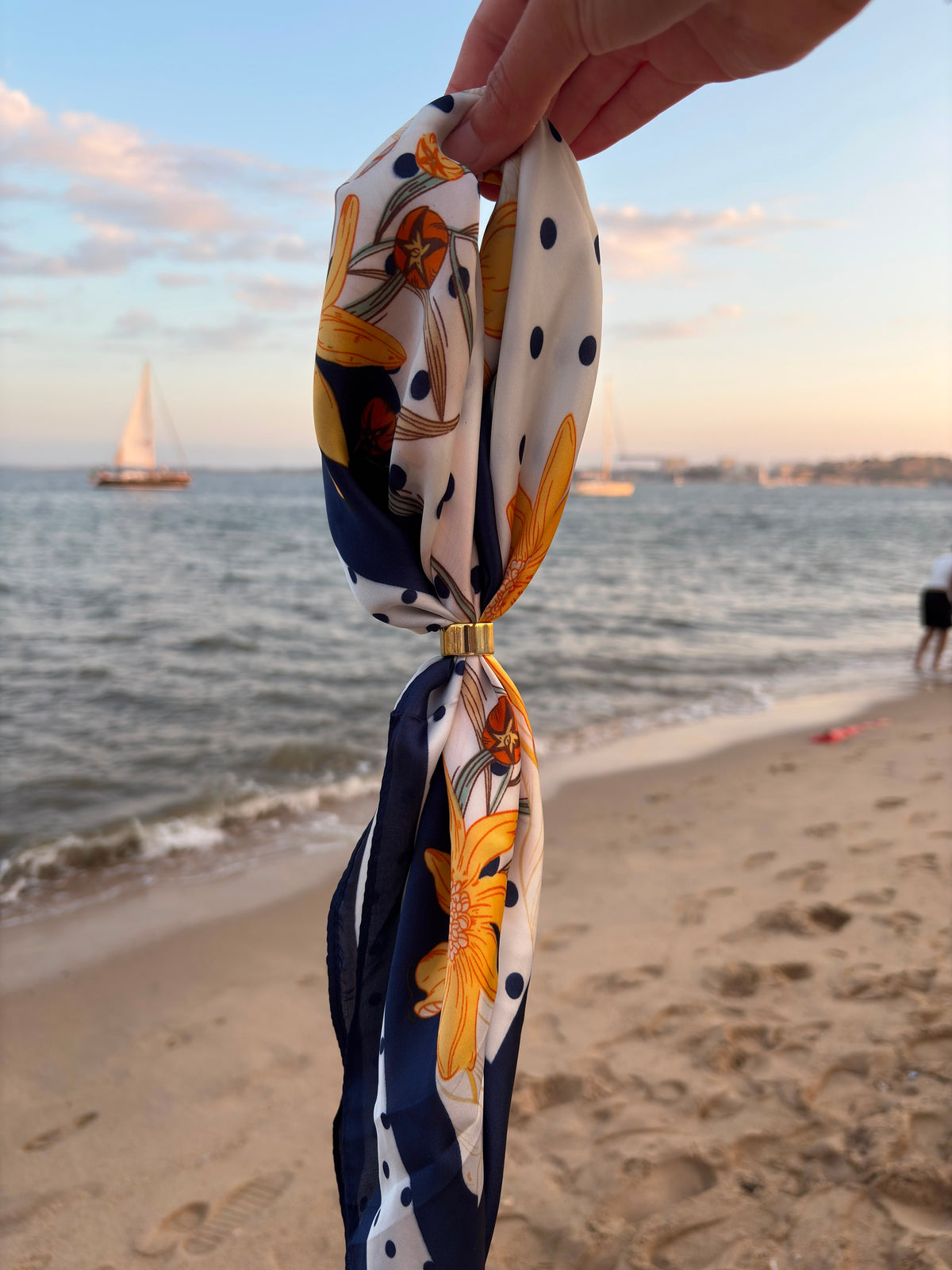 Marinère Scarf held at the beach showing floral reverse