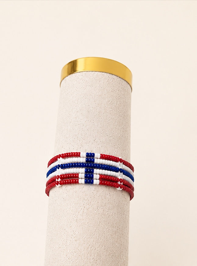 Tintabeads handgemaakte kralenarmband in rood, wit en blauw met Noorse vlagkleuren op een displayhouder.